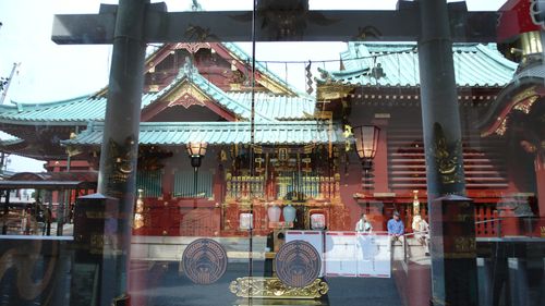 The Shinto shrine reflects in the glass of the altar. 
