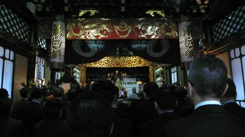 main hall, the chief priest and monks read a sutra aloud.